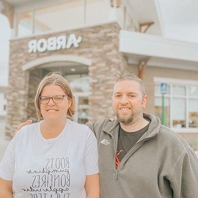 Michelle and Corey standing outside of an Arbor Financial Credit Union location.